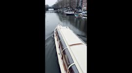 Boat breaks through frozen Amsterdam canal creating satisfying noise