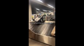 Suitcases covered in snow as tourists collect luggage at Danish airport