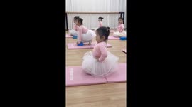 Young student holds posture during ballet training, Guangxi, China