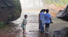 Toddler slips on wet rocks and slides dangerously towards waterfall