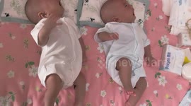 Adorable newborn twins cry together on a mattress in Jilin, China