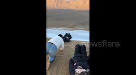 China: Chinese man experiences sudden speed on a sand sliding slope in Xinjiang