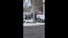 Man draws smiley faces on snow-covered cars in Peabody, Massachusetts, USA
