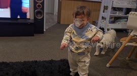 Toddler wears bottle cap as a nose while Dad laughs