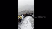 Tourists crawl, cling, and slide down China's Great Wall as heavy snow turns landmark into icy hazard