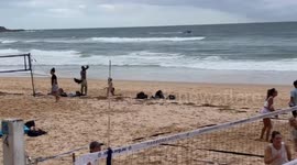 Beachgoers play volleyball just yards from Australia shark attack victim