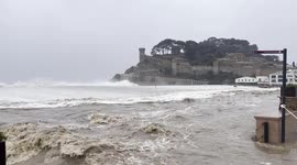 Waves crash over seawall sending floodwater onto streets of Spain's Tossa de Mar