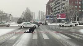 North Macedonia: Man Crawls Across Snow-Covered Crosswalk in Skopje