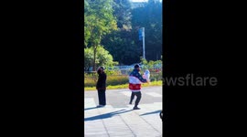 China: Grandfather practices tai chi while holding his grandchild in China