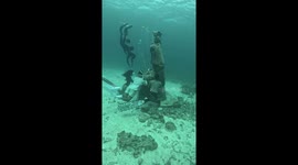 Divers pose next to sunken Child Jesus statue in Philippines