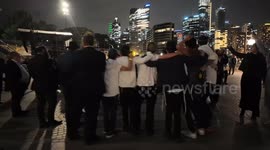Jewish people dance together after national day of mourning event in Sydney, Australia