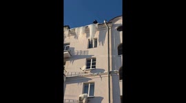 Icicle removal mishap damages air conditioner on snowy roof in Minsk, Belarus