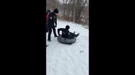 Police officers enjoy sledging in fresh snow after winter storm