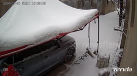 Elderly woman accidentally punctures car tent roof while removing snow in Henan, China