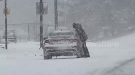 Driver struggles with wiper during heavy snowstorm in Rochester, New York, USA