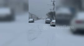 Residents ride snowmobiles on ice-covered roads as winter storm sweeps the US