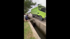 Lorry raises hydraulic lift to retrieve motorbike stuck ditch