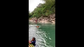 Swimming food vendor sells ice creams to tourists on passing raft