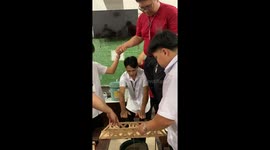 Student stands on top of popsicle bridges for durability test