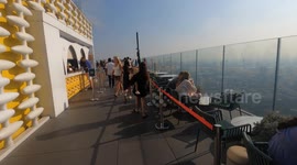 Tourists play on skyscraper's glass walkway 1,000ft above streets