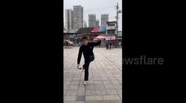 China: Chinese man performs smooth gliding dance steps in public square