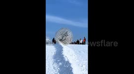 China: Inflatable snowball ride sends two Chinese visitors rolling down ski slope