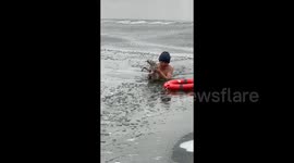 Heroic moment man dives into frozen lake to rescue wailing stray dog that fell through ice