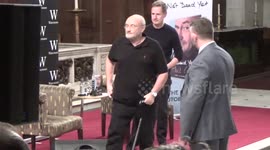 Phil Collins appears to struggle to get out of chair at Q&A in London