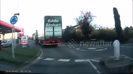 Eddie Stobart lorry doing a U-turn on a mini roundabout, but crashing into 2 bollards