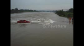 Car trying to cross river gets stuck