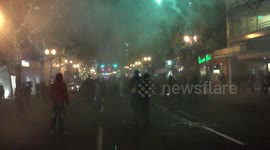 People shoot fireworks towards police in Anti-Trump riot