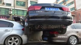 Bizarre accident leaves one car balancing on top of two cars