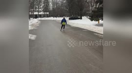 Boy ice-skates on frozen road in Ontario, Canada