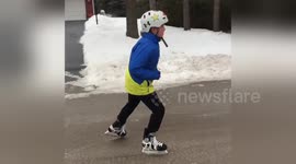 Boy ice-skates on frozen road in Ontario, Canada