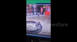 Woman looking at her phone falls into mall fountain pool