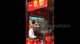 Enthusiastic man pulls single-strand noodle while dancing