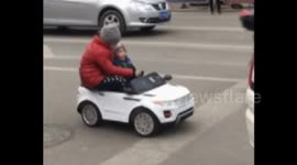 Four-year-old girl and her younger brother drive toy car on road